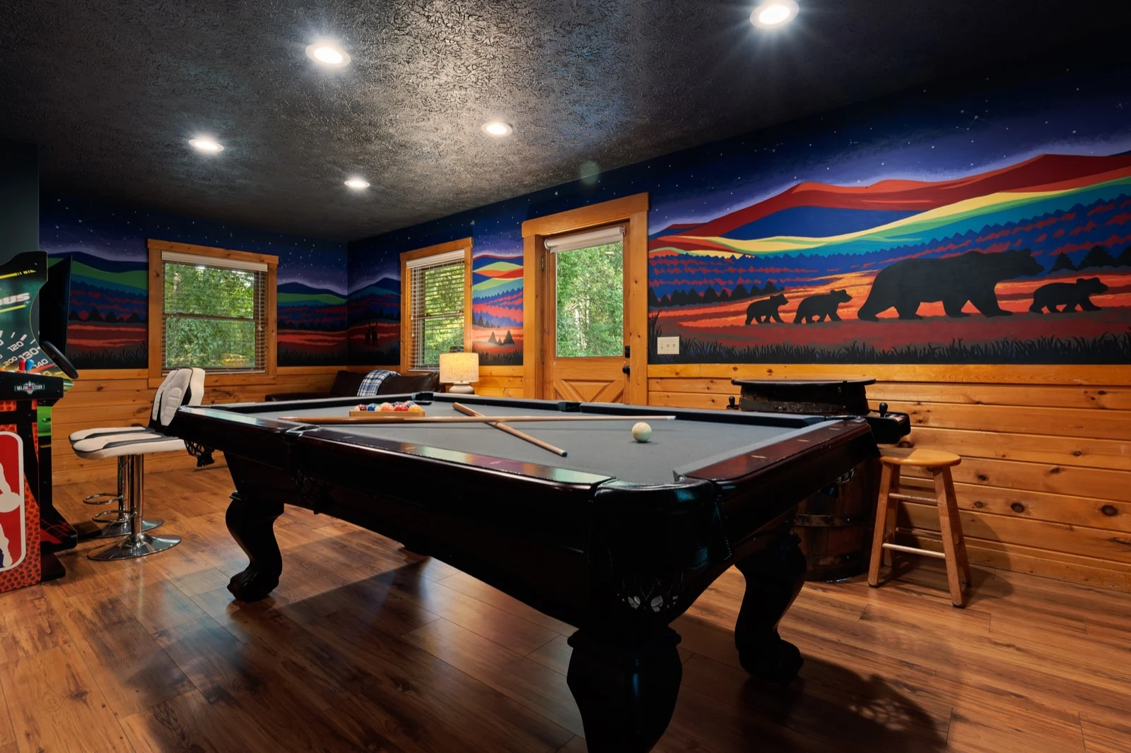 Pool table and colorful mountain mural in the game room